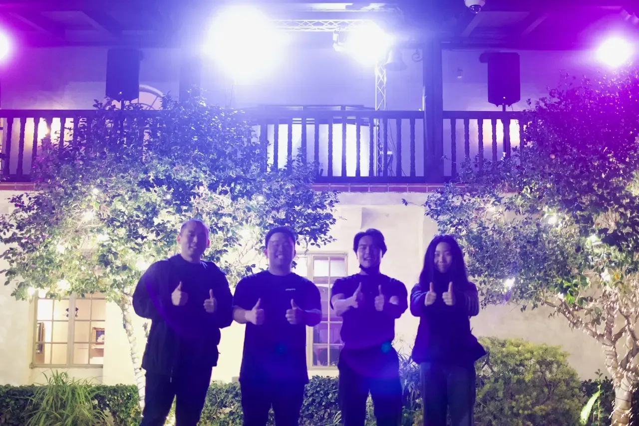 The Community Mixers team together beneath purple event lighting