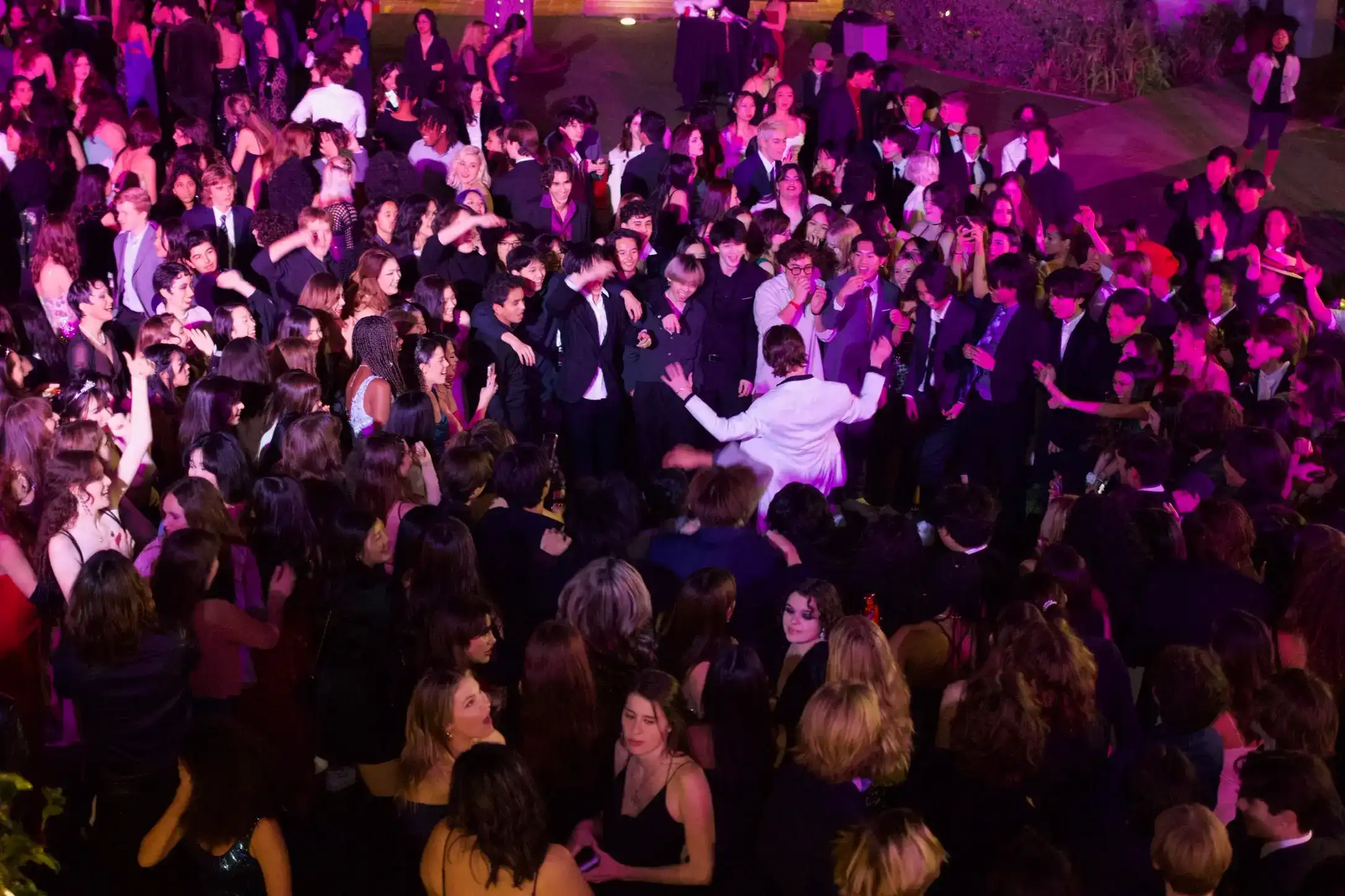 A packed Community Mixers dance floor seen from above, guests mid-celebration under warm light