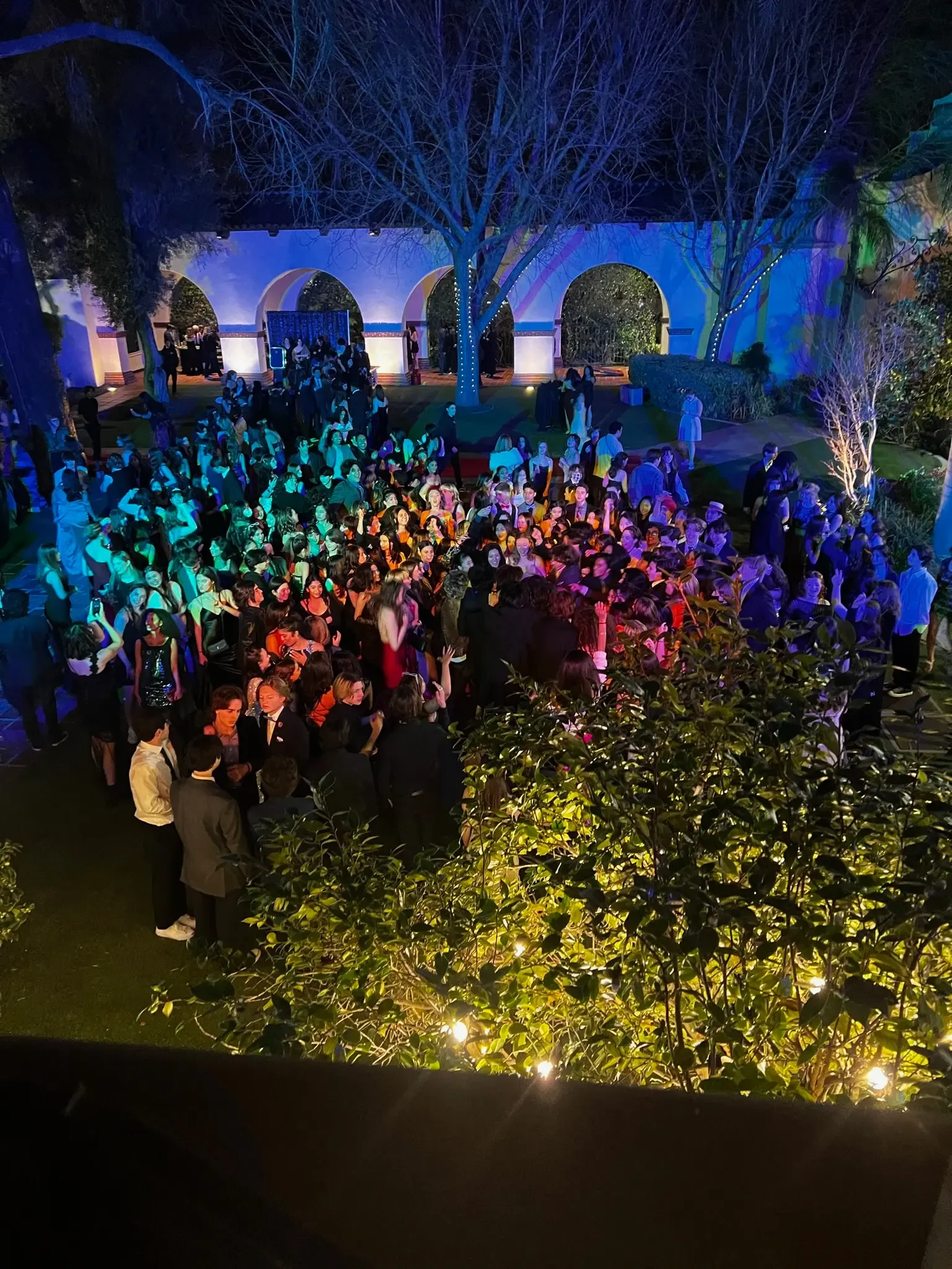 Students on a courtyard dance floor under blue lighting