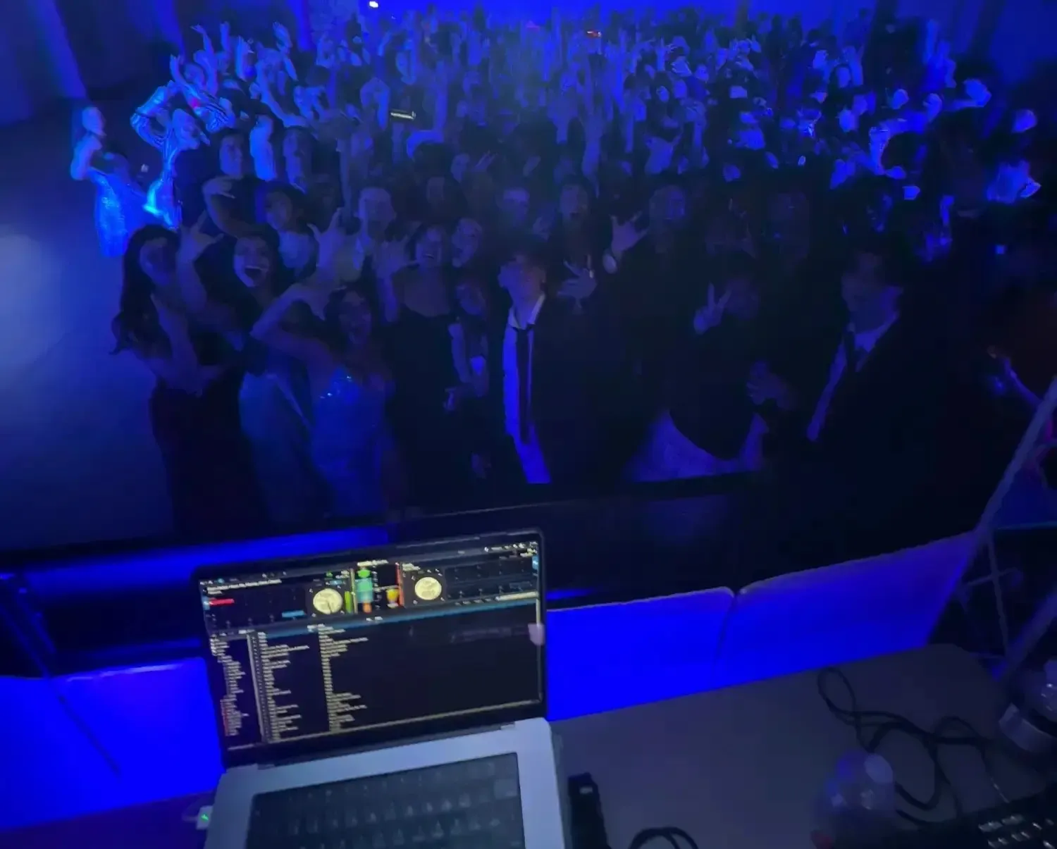 The crowd cheering, seen from the DJ booth